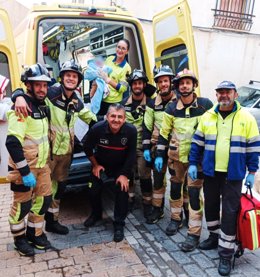 Una sanitaria posa con el recién nacido junto a bomberos y otros facultativos