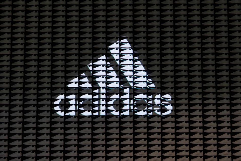 Archivo - FILED - 08 March 2023, Bavaria, Herzogenaurach: The logo with lettering of the sporting goods manufacturer adidas AG is projected onto a wall consisting of sneakers on the sidelines of the company's annual press conference. Adidas sued by inve