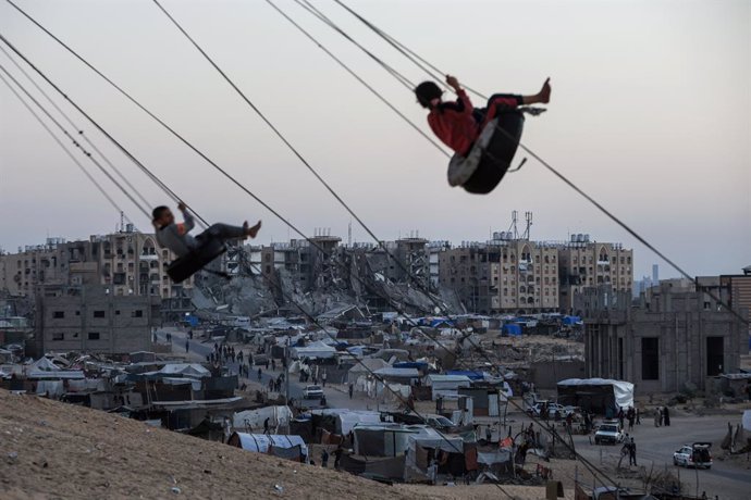 October 28, 2024, Gaza, Gaza, Palestine: Palestinian children play on a swing between the tents of displaced people in the Khan Yunis camp in the southern Gaza Strip on October 28, 2024.,Image: 927497612, License: Rights-managed, Restrictions: , Model Rel