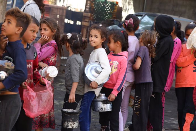 25 October 2024, Palestinian Territories, Dair El-Balah: Displaced Palestinians children queue to receive food rations offered by a charity. Gaza is experiencing a continuously deteriorating humanitarian situation as Israel continues to obstruct aid entry