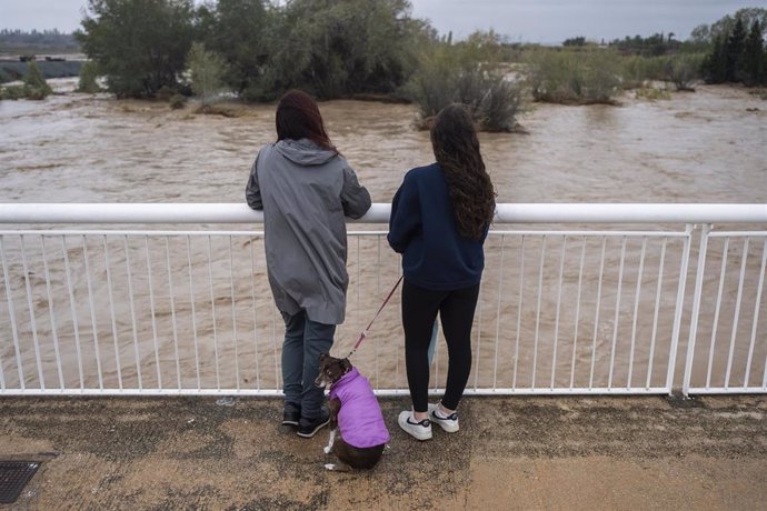 Varias personas observan la crecida del río Magre