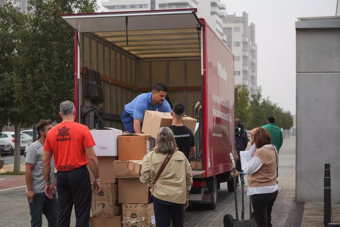 Varias personas llevan cajas con mantas, ropas y objetos de primera necesidad para las personas que se encuentran en el pabellón de baloncesto, 'La Fonteta', a 30 de octubre de 2024, en Valencia. 