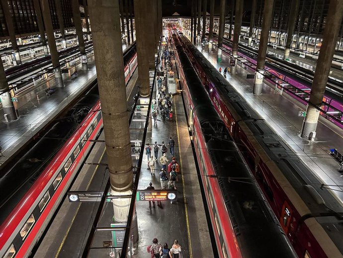 Personas en el andén esperan para montar en trenes