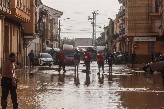 Varias personas en una calle llena de agua tras el paso de la DANA por el barrio de La Torre de Valencia, a 30 de octubre de 2024, en Valencia, Comunidad Valenciana (España). 