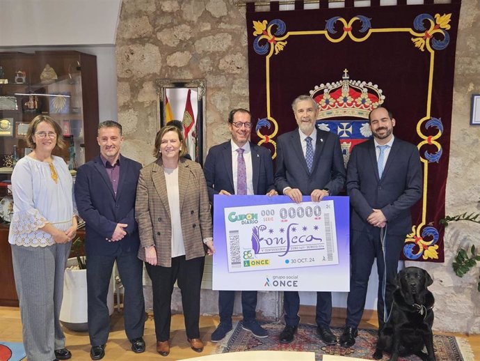 El rector de la Universidad de Burgos, Manuel Pérez Mateos, y la profesora titular de Historia de América, , reciben de las manos del delegado ONCE en Castilla y León, Ismael Pérez Blanco, el cupón.