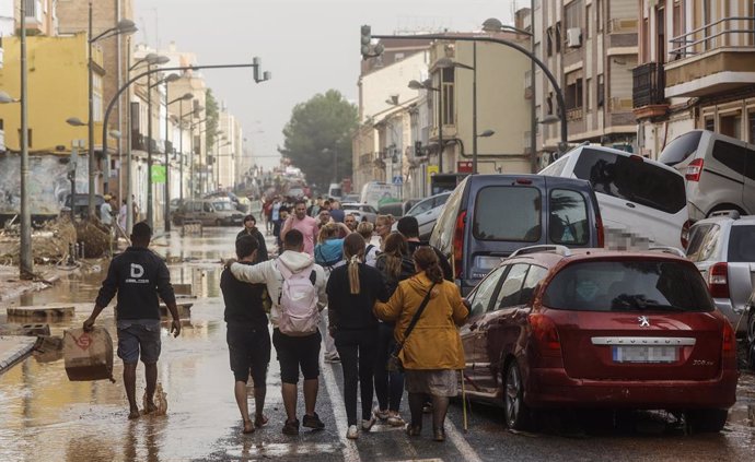 Varias personas junto a coches destrozados tras el paso de la DANA por el barrio de La Torre de Valencia, a 30 de octubre de 2024, en Valencia, Comunidad Valenciana (España). La Comunitat Valenciana ha registrado la gota fría "más adversa" del siglo en la