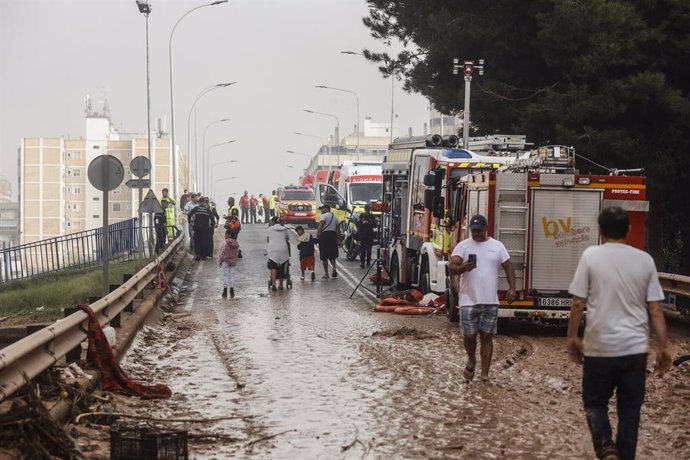 Varias personas y bomberos tras el paso de la DANA por el barrio de La Torre de Valencia