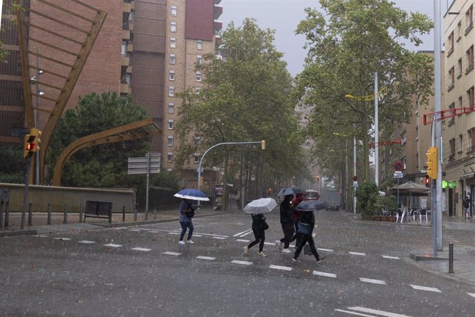 Varias personas con paraguas durante la tormenta, a 30 de octubre de 2024, en Barcelona, Catalunya (España). 