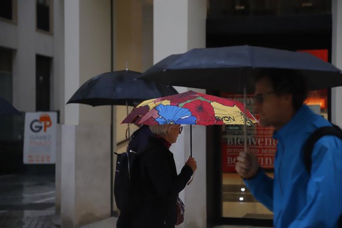 Personas con paraguas por las calles de Málaga, a 29 de octubre de 2024, en Málaga, Andalucía (España). Málaga y varias zonas de su provincia están bajo aviso rojo debido a un intenso episodio meteorológico provocado por una Depresión Aislada en Niveles