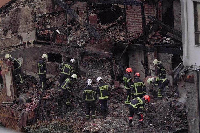 Agentes del equipo de bomberos trabaja en el edificio derrumbado