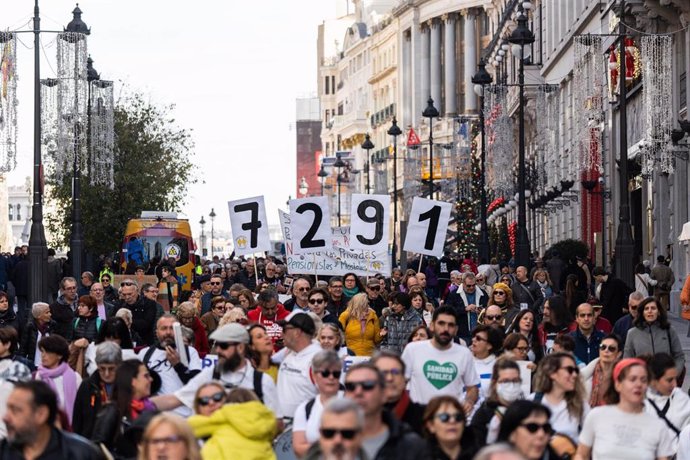 Archivo - Varias personas llevan carteles que indican el número de residentes muertos en pandemia durante una manifestación en memoria de los residentes fallecidos durante la primera ola de la pandemia.