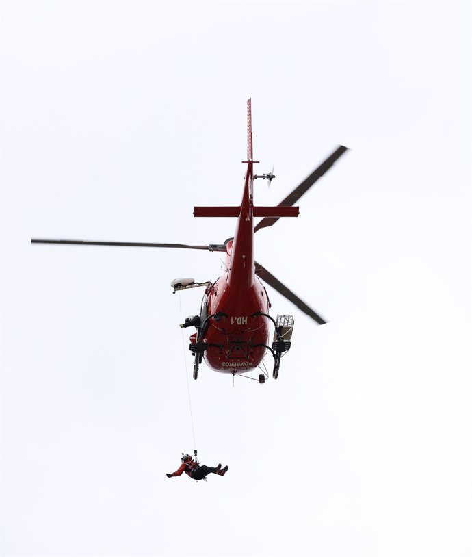 Archivo - Un miembro del GERA hace una demostración desde un helicóptero durante la celebración del XXV aniversario de la creación del Grupo Especial de Rescate en Altura (GERA), en el parque de bomberos de Navacerrada, a 16 de diciembre de 2022, en Navac