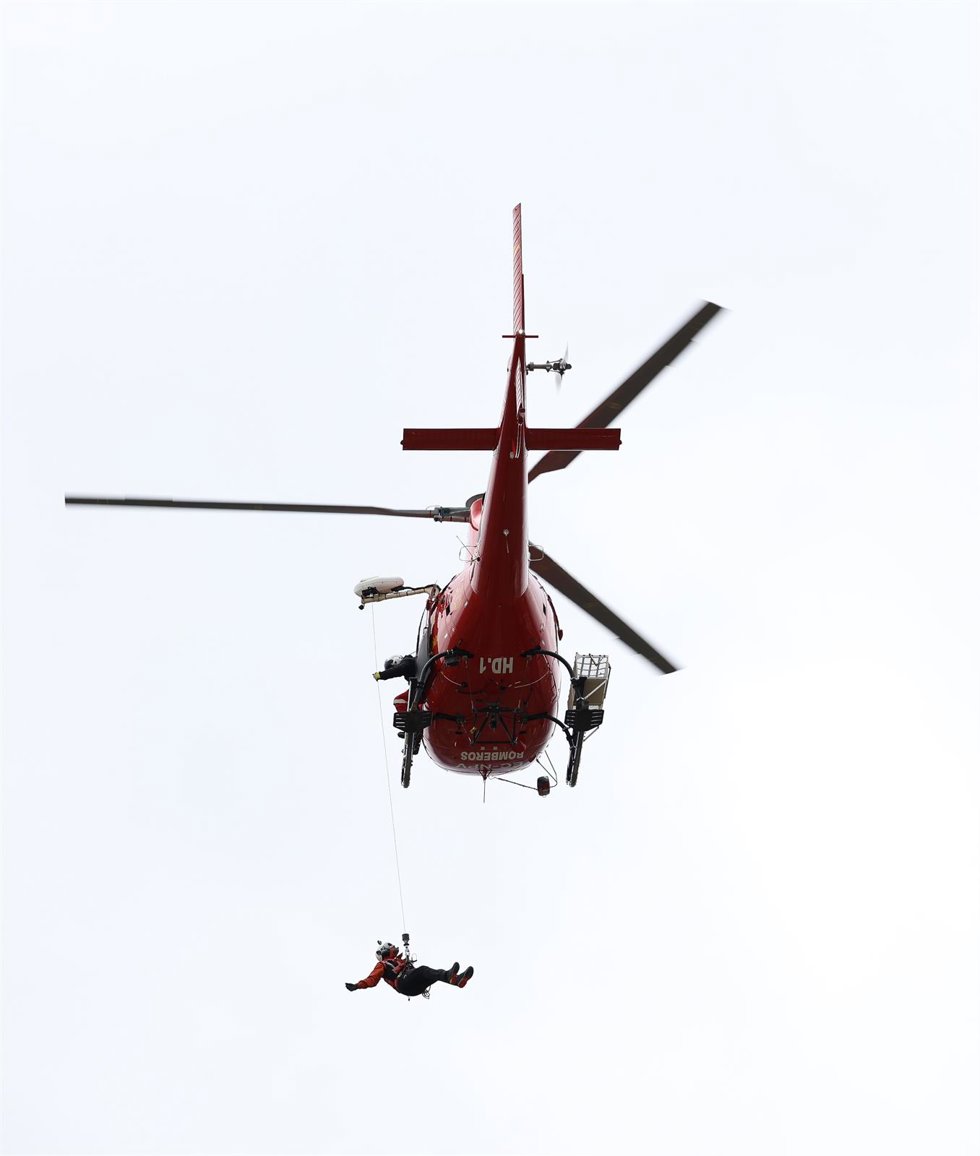 Archivo - Un miembro del GERA hace una demostración desde un helicóptero durante la celebración del XXV aniversario de la creación del Grupo Especial de Rescate en Altura (GERA), en el parque de bomberos de Navacerrada, a 16 de diciembre de 2022, en Nav