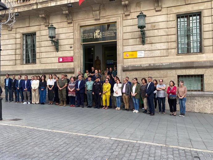 Representantes de las instituciones y diversos organismos guardan un minuto de silencio frente a la Delegación de Gobierno en Baleares.