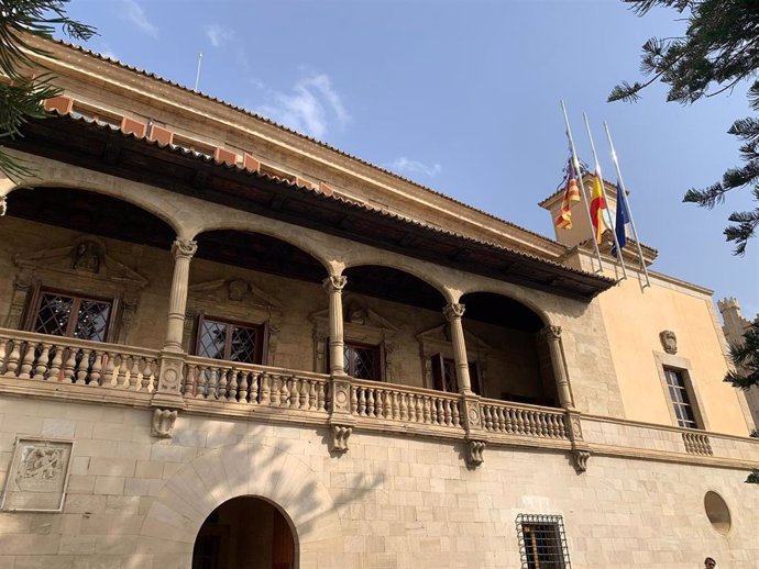 Las banderas en el Consolat de Mar ondean a media asta durante los tres días de luto por los fallecidos a causa de la DANA