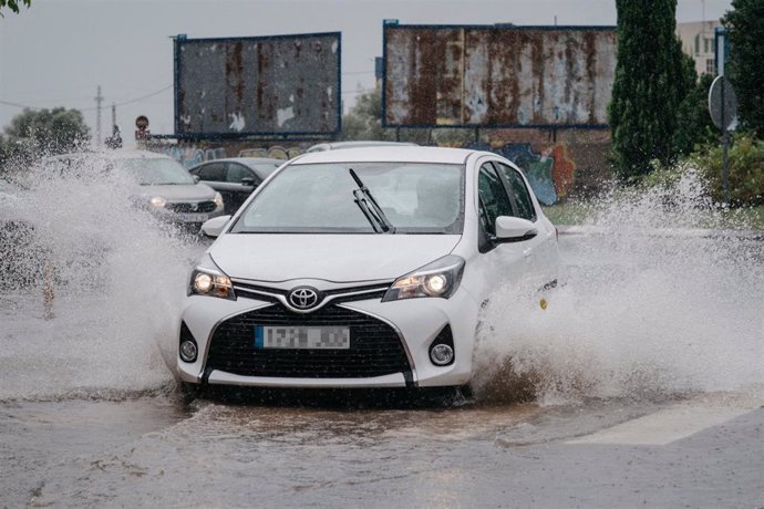 Archivo - Un coche circula bajo la lluvia.