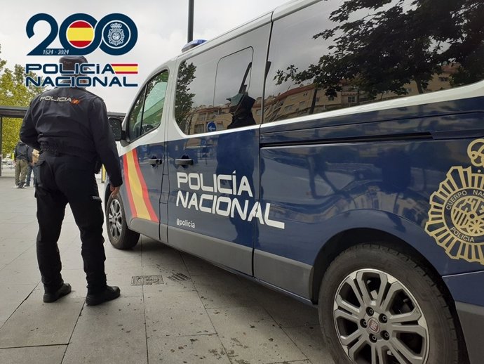 Imagen de archivo de un agente de la Policía Nacional junto a un furgón.