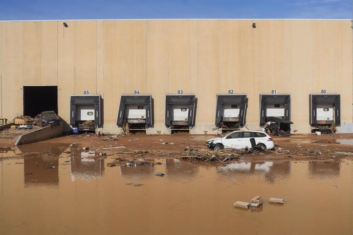 Vehículos hundidos en el barro en el polígono de Riba-roja tras el paso de la DANA