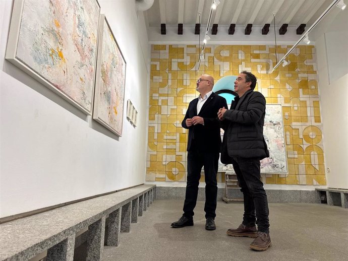 El pintor Iván Montero (dcha) muestra la exposición al concejal de Cultura, Juan Carlos Monroy.