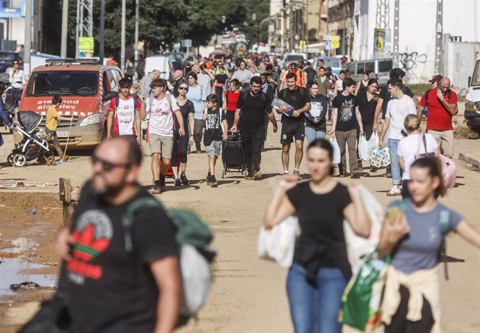 Varias personas con bolsas tras el paso de la DANA en el barrio de La Torre, a 31 de octubre de 2024, en València