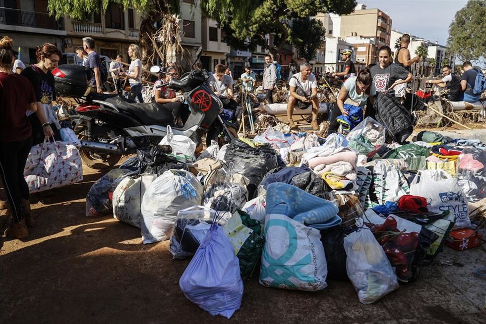Varias personas limpian los estragos ocasionados por la DANA este viernes en Paiporta