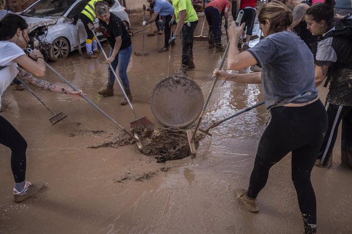 Varias personas limpian los estragos ocasionados por la DANA