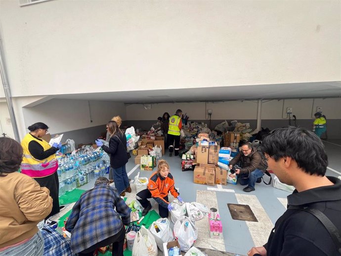 Varios vecinos y voluntarios colaborando en un punto de recogida de productos de primera necesidad para los afectados por la DANA