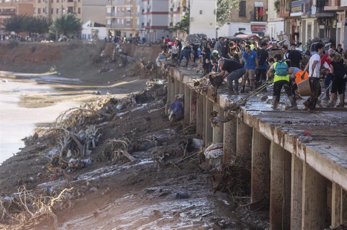 Varias personas limpian los estragos ocasionados por la DANA en Paiporta, Valencia