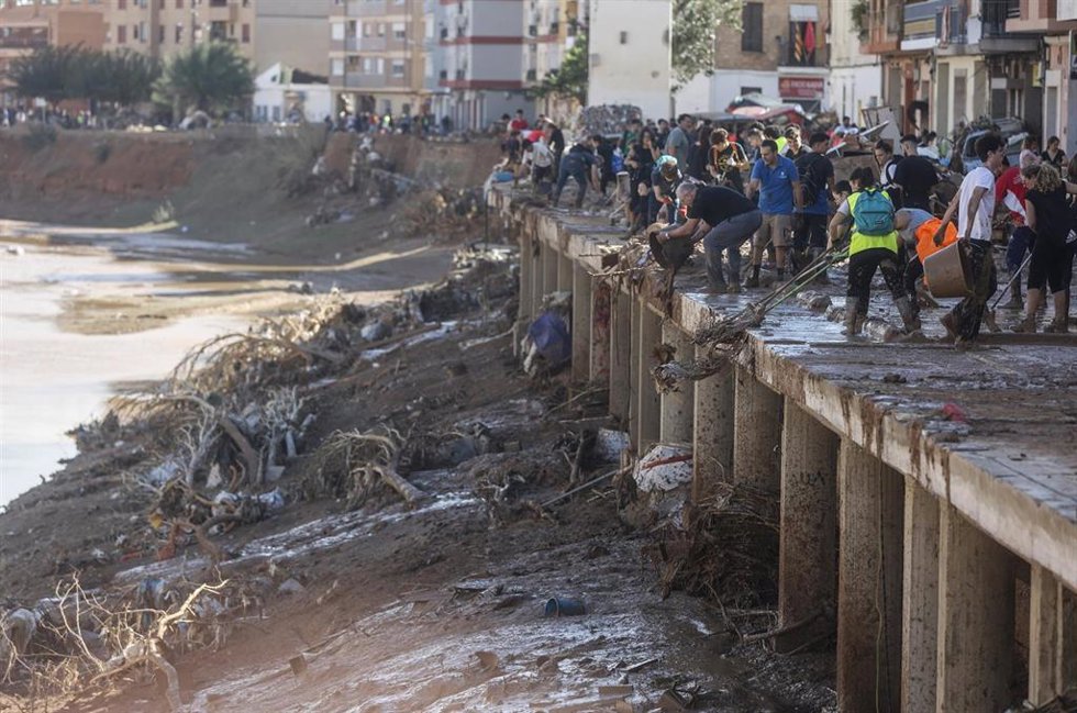 Varias personas limpian los estragos ocasionados por la DANA en Paiporta, Valencia