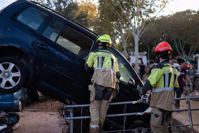 Dos bomberos trabajan en una zona afectada por la DANA,  