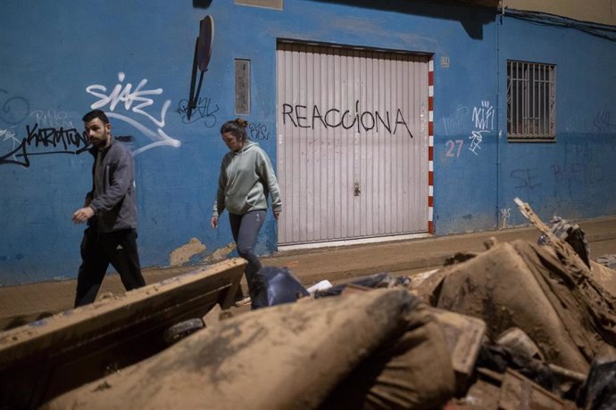 Dos personas caminan entre escombros, a 2 de noviembre de 2024, en Benetusser, Valencia, Comunidad Valenciana (España). 