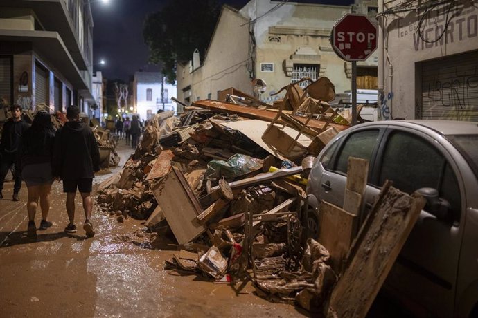 Varias personas caminan entre escombros, a 2 de noviembre de 2024, en Benetusser, Valencia, Comunidad Valenciana (España). Más de 200 voluntarios de Protección Civil de toda España están participando en las tareas de emergencia como consecuencia de la DAN