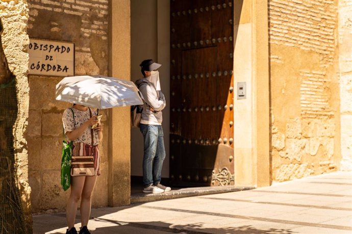 Archivo - Turistas y cordobeses se resguardan del sol 