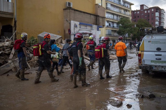 Varios bomberos tratan de achicar agua y barro, a 2 de noviembre de 2024, en Alfafar, Valencia, Comunidad Valenciana (España). Más de 200 voluntarios de Protección Civil de toda España están participando en las tareas de emergencia como consecuencia de la