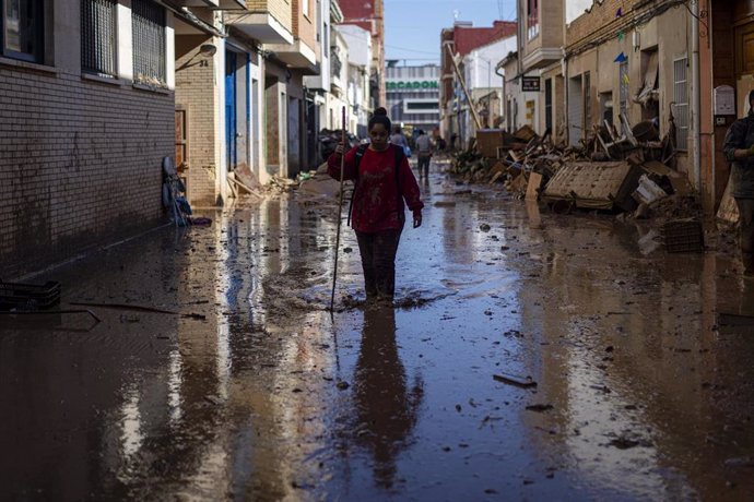 Varias personas retiran agua y barro en Valencia