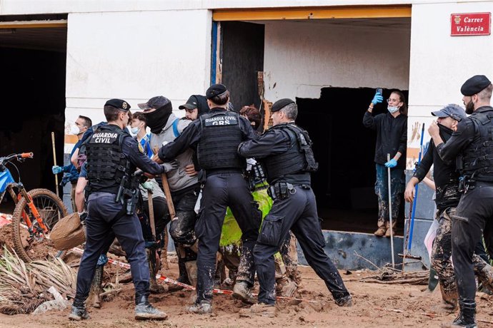 Agentes de la Guardia Civil paran a varias personas que increpan a las autoridades encabezadas por el Rey durante su visita a una zona afectada por la DANA