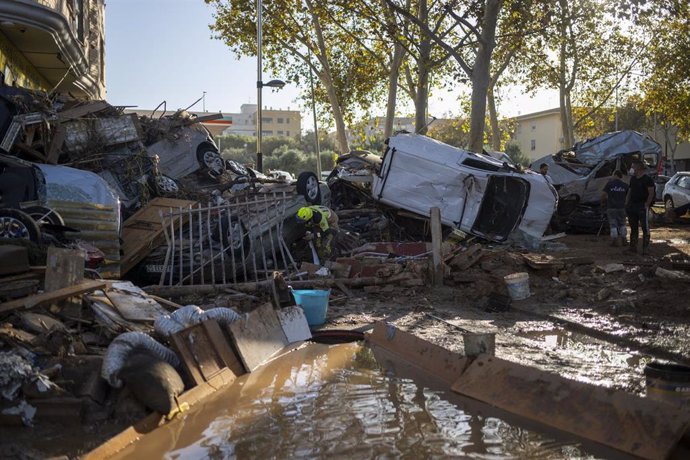 Varios bomberos buscan a personas entre coches, a 2 de noviembre de 2024, en Alfafar (Comunitat Valenciana)