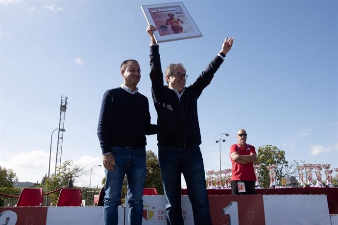 El diputado de Deportes de la Diputación de Cáceres, Pablo Miguel López, le entrega el cartel al ex atleta José Ignacio Fernández, homenajeado en esta edición del trofeo