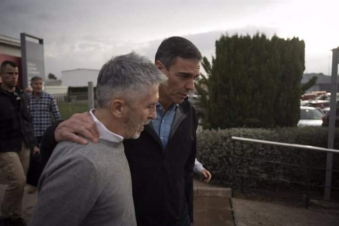 El presidente del Gobierno, Pedro Sánchez (d), y el ministro del Interior, Fernando Grande-Marlaska (i), durante su visita al centro del 112