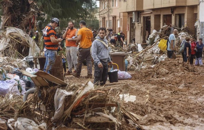 Varias personas limpian los estragos ocasionados por la DANA, 