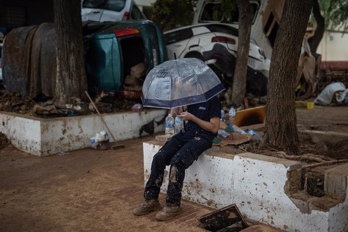 Imagen de un hombre protegiéndose de la lluvia con un paraguas en una de las localidades valencianas afectadas por la DANA.  