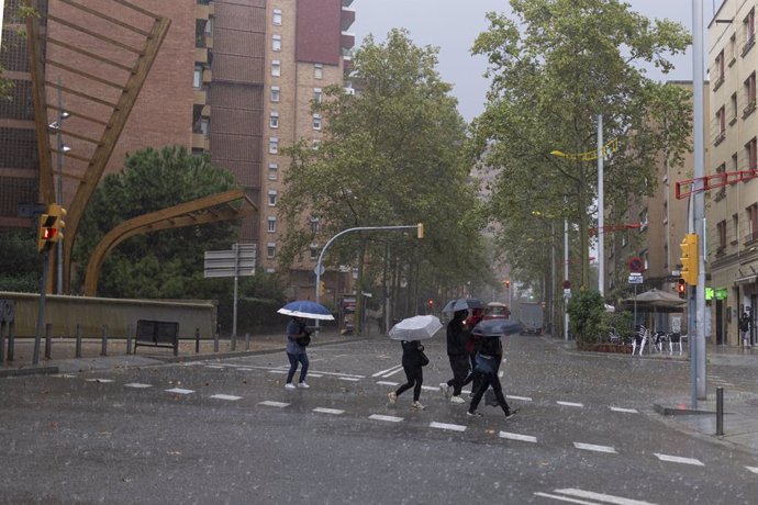 Diverses persones amb paraigües durant la tempesta, a 30 d'octubre del 2024, a Barcelona, Catalunya (Espanya)