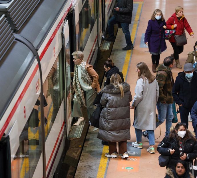 Archivo - Varias personas con y sin mascarilla entran y salen de un vagón del tren en el andén de la estación Puerta de Atocha-Almudena Grandes, a 8 de febrero de 2023, en Madrid (España).