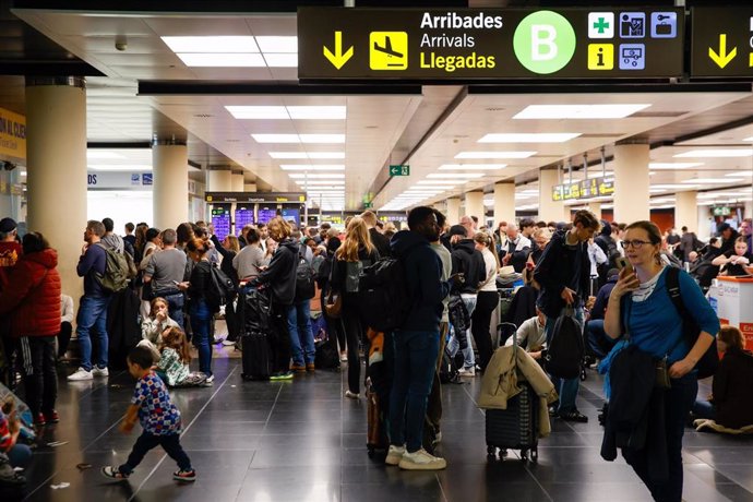 Varias personas en el aeropuerto de Barcelona-El Prat, a 4 de noviembre de 2024, en la T-2, en El Prat de Llobregat, Barcelona, Cataluña (España). El aeropuerto ha desviado 12 vuelos por las lluvias. El Servei Meteorològic de Catalunya (SMC) ha emitido un