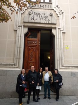 Un familiar de víctimas que murieron en su domicilio durante la pandemia de Covid sin recibir asistencia junto a miembros de la delegación de la conferencia 'Miles de personas en situación de dependencia discriminadas', este lunes, en Madrid.