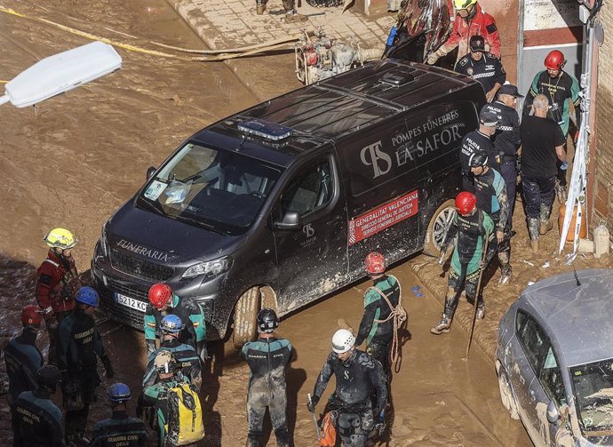 Un furgón de la funeraria sale de un garaje con cadáveres localizados tras el paso de la DANA