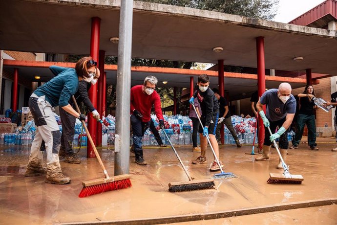 Voluntarios retiran agua este lunes en Picaña, en un instituto que han utilizado como almacén tras el paso de la DANA