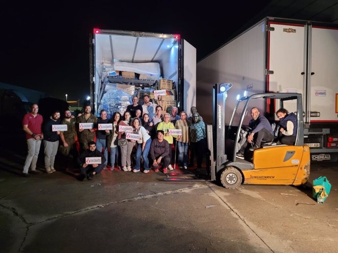 Camiones de la Hermandad de Emigrantes antes de salir a repartir las donaciones a Valencia.