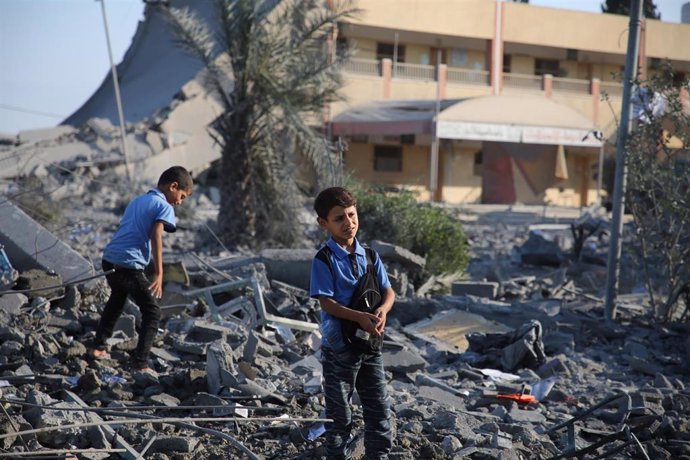 Archivo - Dos niños gazatíes entre los escombros tras un bombardeo del Ejército israelí en Jan Yunis