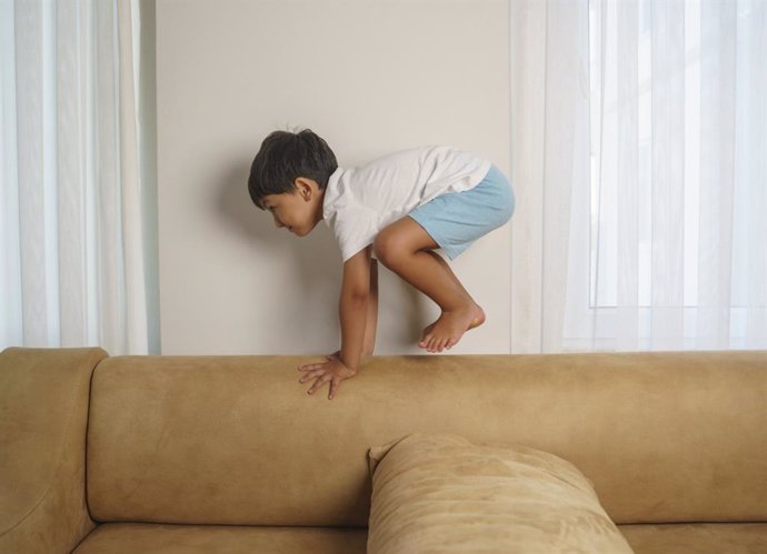 Archivo - Niño jugando en el sofá de su casa